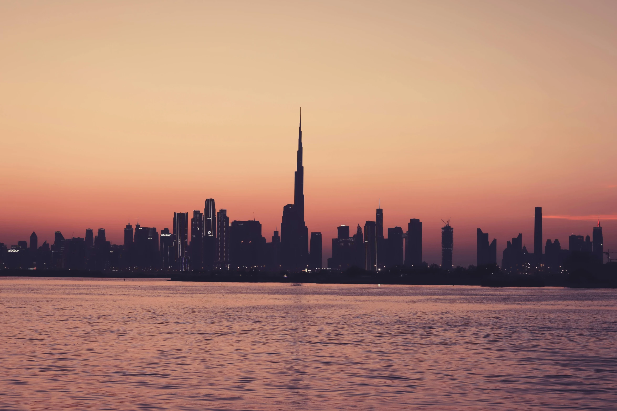 a city skyline with the lights on and people looking on