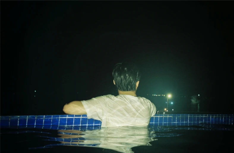 a man standing in a pool at night