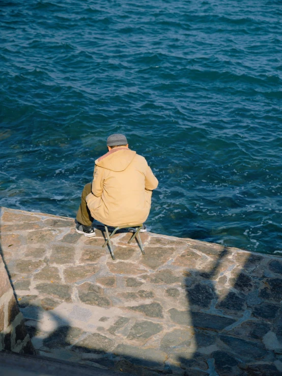 a person sitting on top of a stone wall