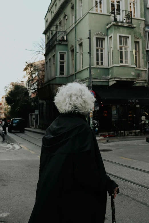 the elderly woman is walking across the street