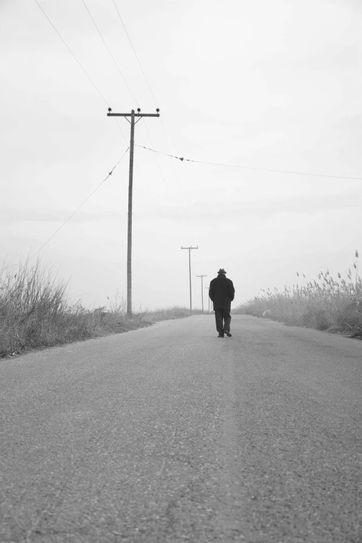 a man is walking down the middle of a road