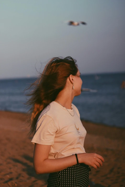 a woman standing on top of a sandy beach