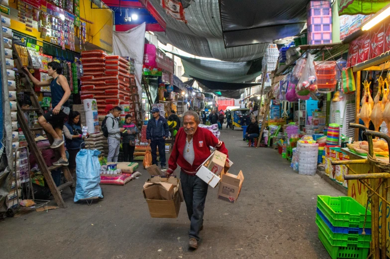 a man carrying shopping bags walking through a market