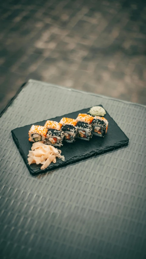 sushi on a black table with some mustard