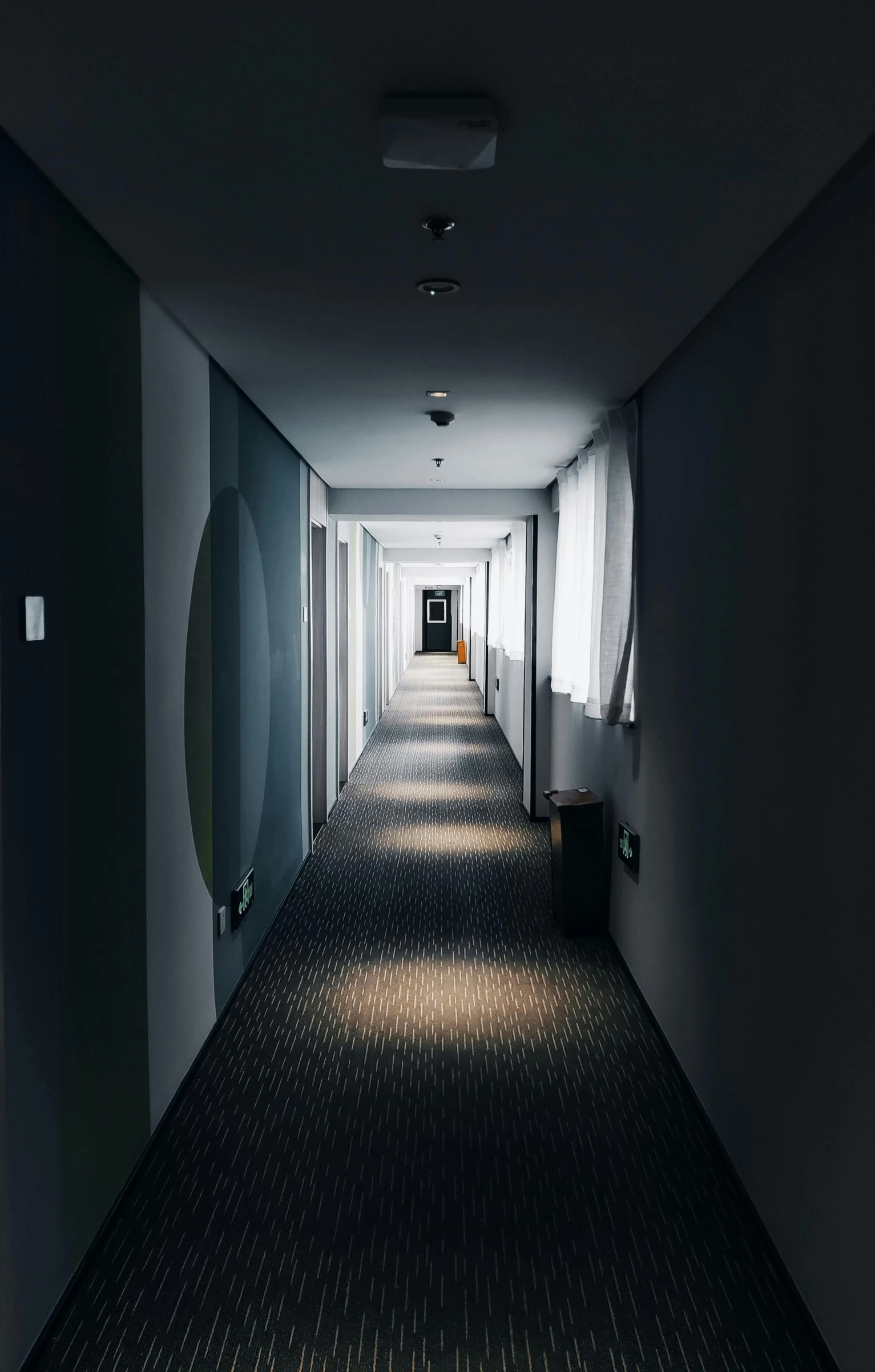 an empty room with light streaming down a hallway