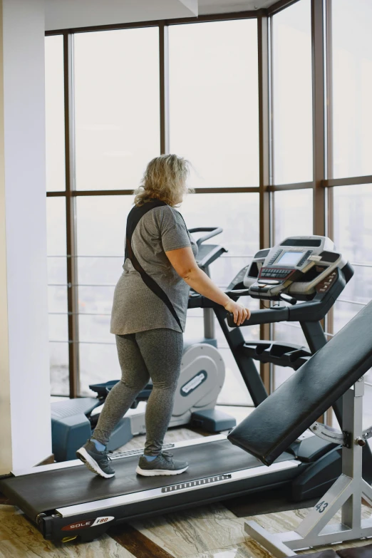 a woman running on an incline at a gym