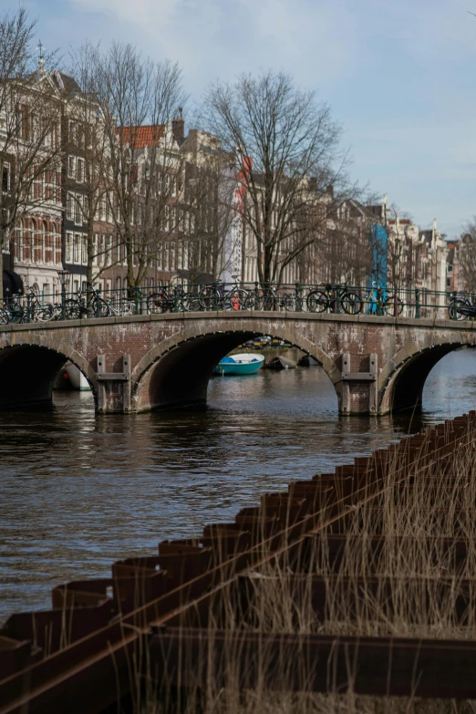 an old bridge crosses over the water near a town