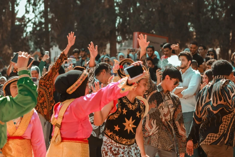 a large group of people are celeting with their hands up