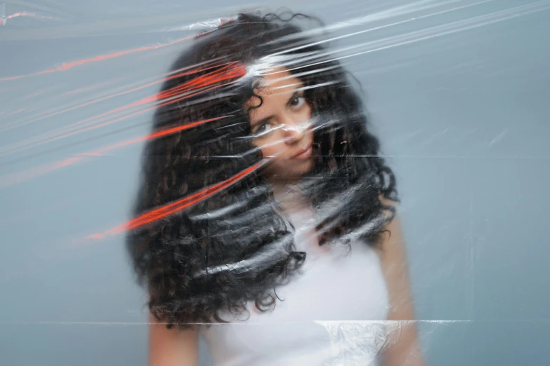 a woman is reflected in a piece of plastic