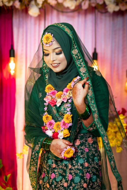 a beautiful woman dressed in green wearing flower leis