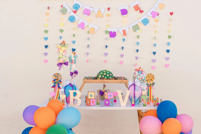 an elaborate party table for a birthday with balloons