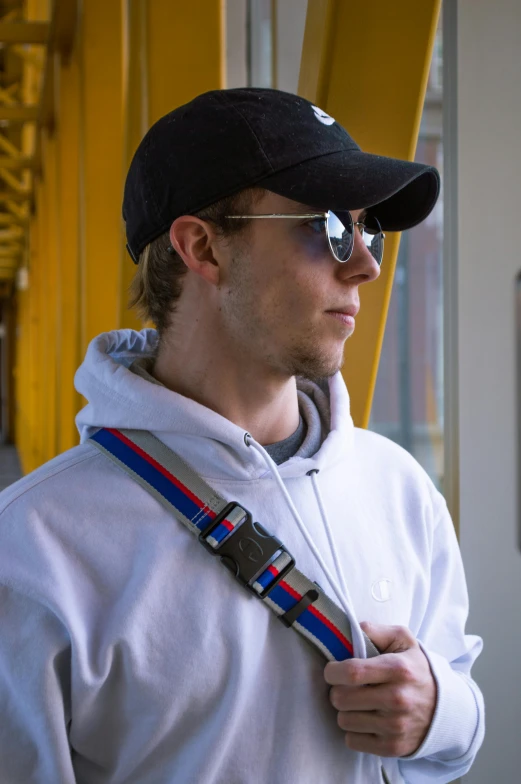 a young man wearing sunglasses and a black hat