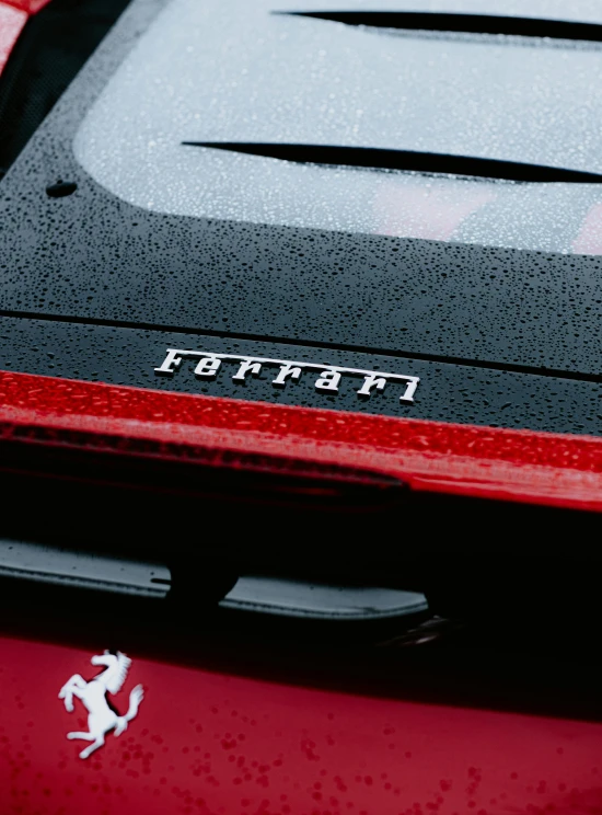 the rear of a red sports car with a horse sticker