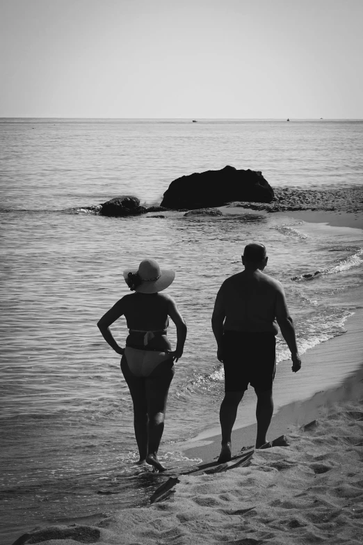 two people that are standing on a beach