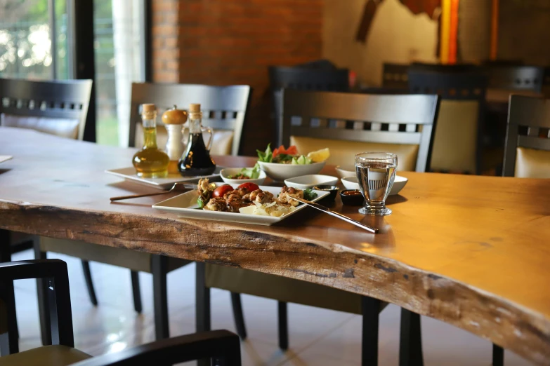 a wooden table topped with a white plate filled with food