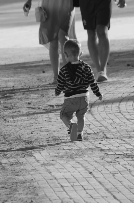 black and white pograph of child walking down the sidewalk