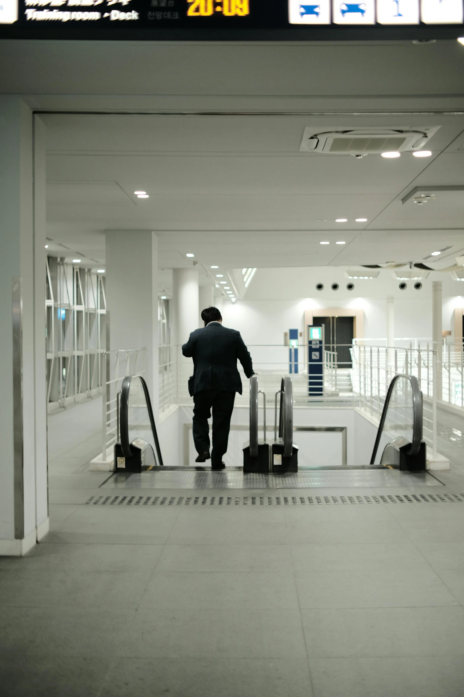 the man is going down an escalator and stepping in