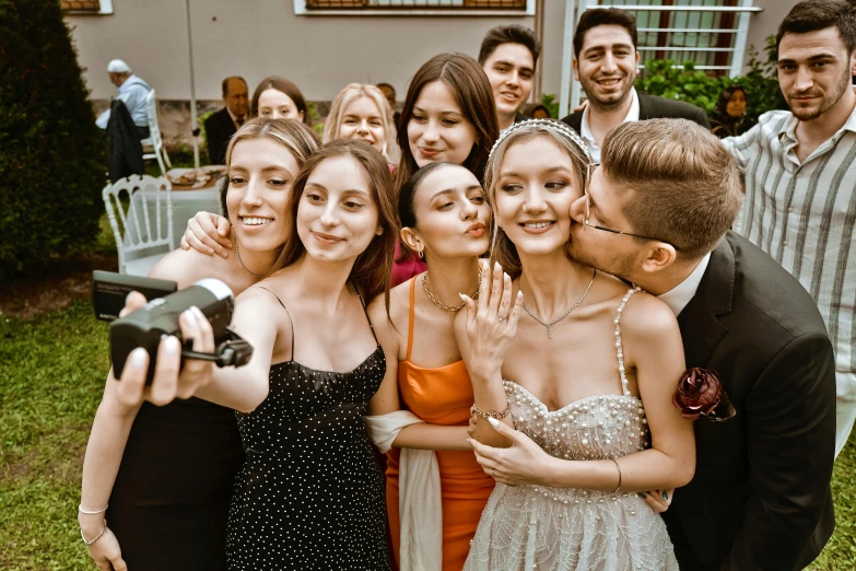 a group of friends taking a selfie in front of a house