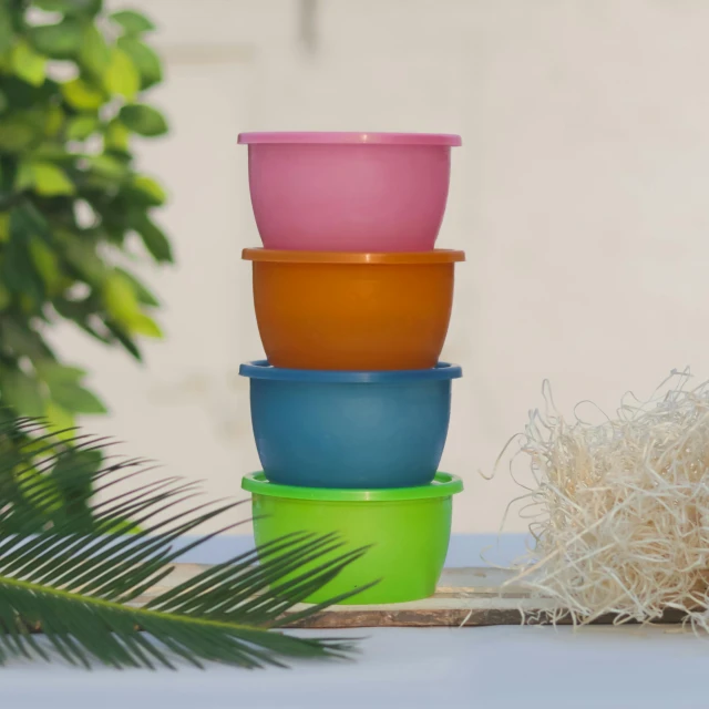 some stacked containers next to a pot of grass