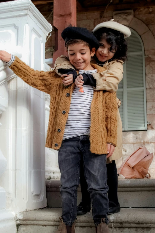 two little boys pose in front of some steps