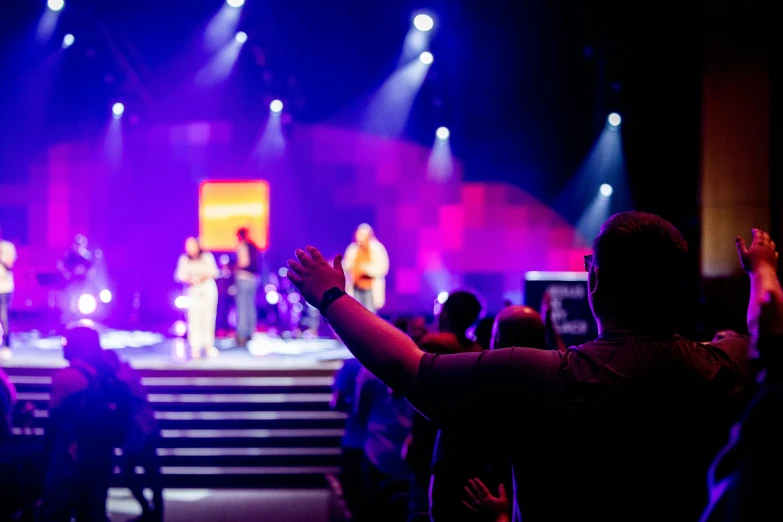 a person on stage giving an oath for people with their hands raised