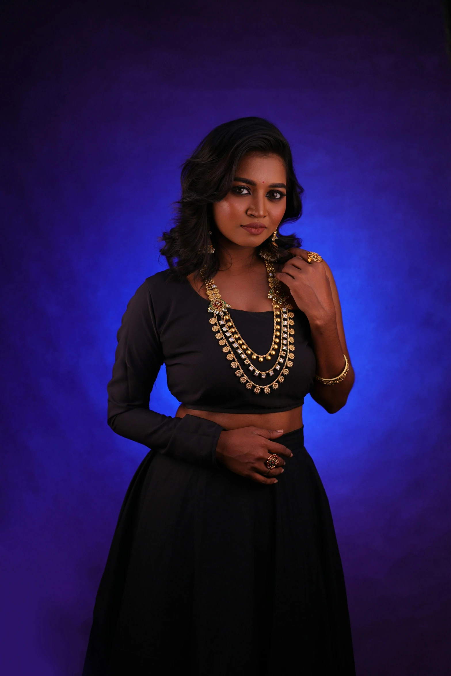 a woman in a black and brown dress with jewelry