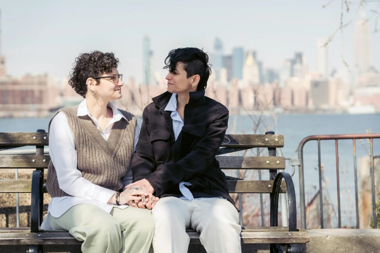 two young men sitting on a bench next to each other