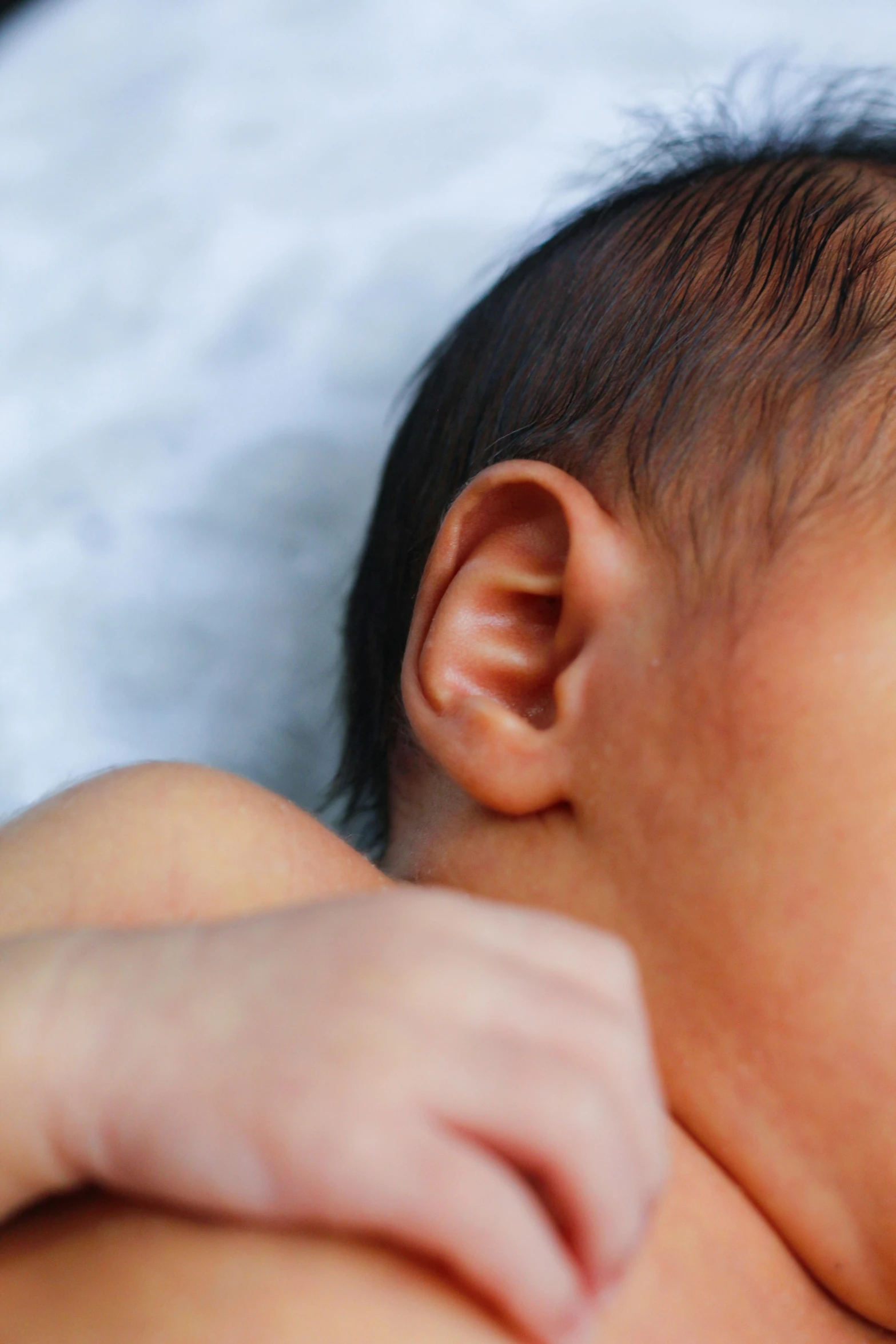 an infant is lying on a bed with its head down