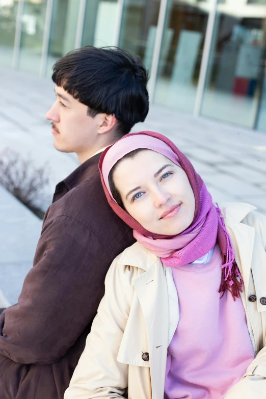 two people sitting next to each other on the sidewalk