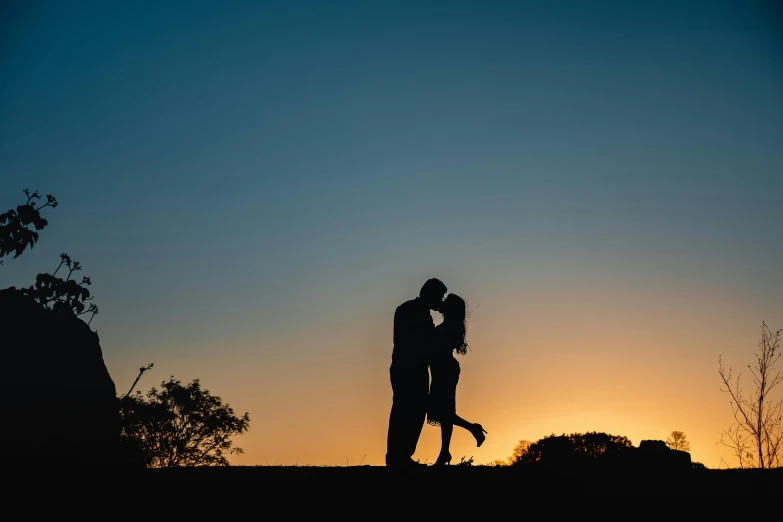 couple silhouette in sunset with arms around each other