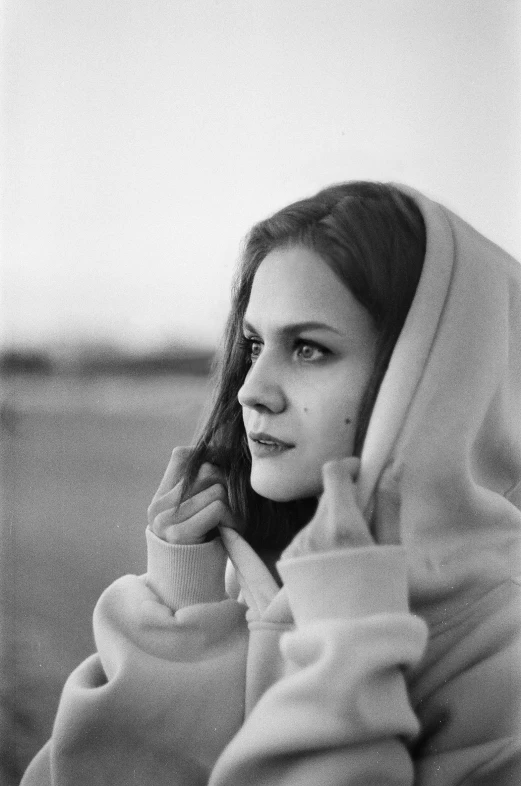 black and white po of woman in hoodie looking off to the side