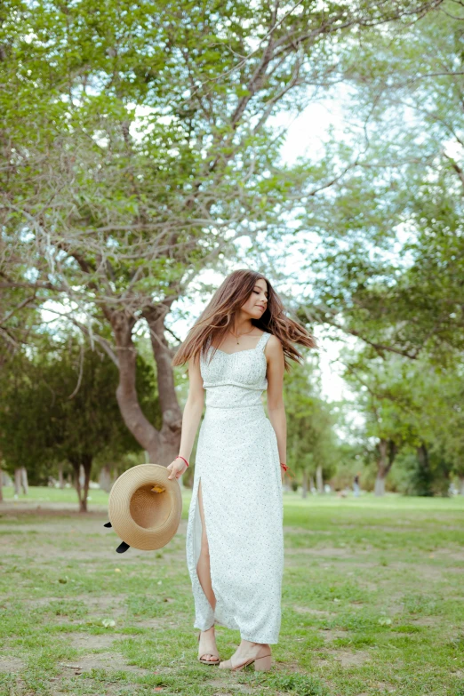 the young woman has a large straw hat in her hand