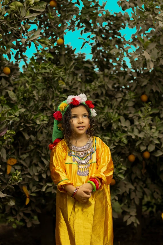 a small girl standing in front of some trees with oranges