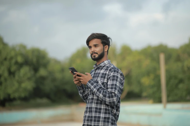 a man in a checked shirt using a cell phone