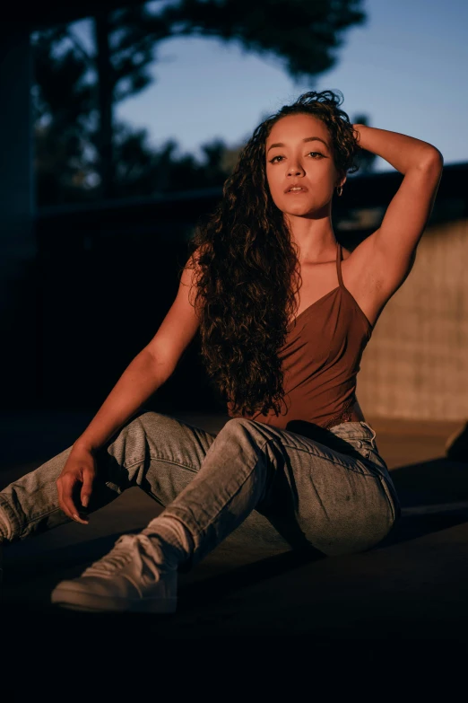 a woman is sitting down with her hands on her hair