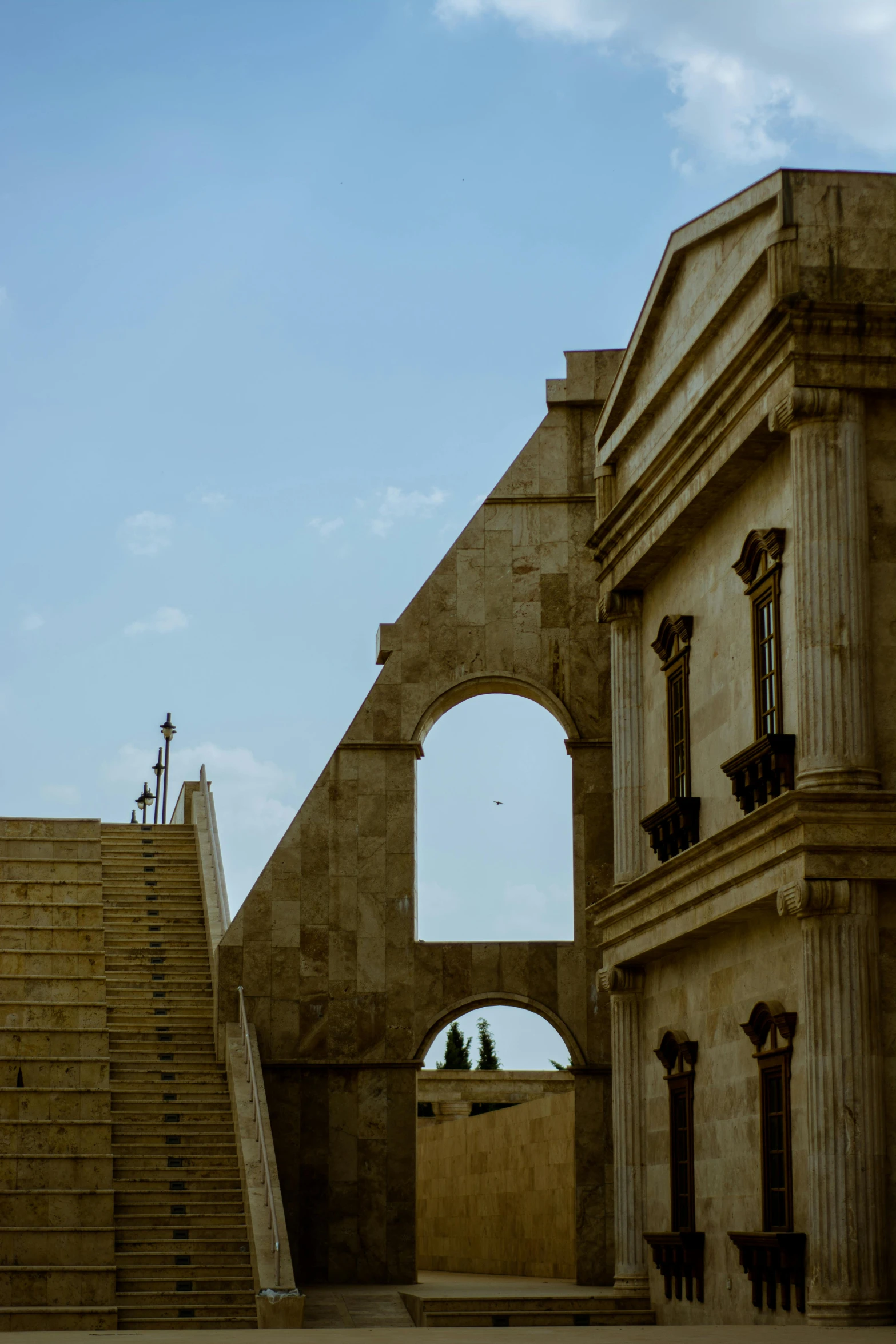 two buildings with steps, arched windows and cross on them