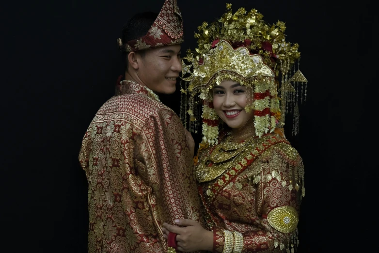 a man and woman pose together in traditional thai garb