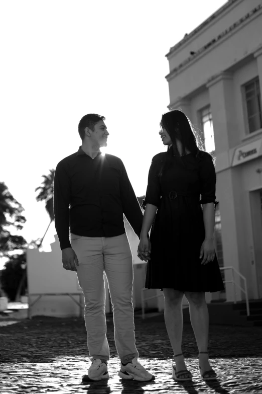 a couple holding hands walking across a street