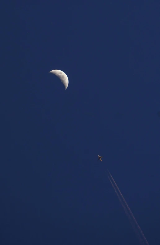 an airplane with the moon in the sky above