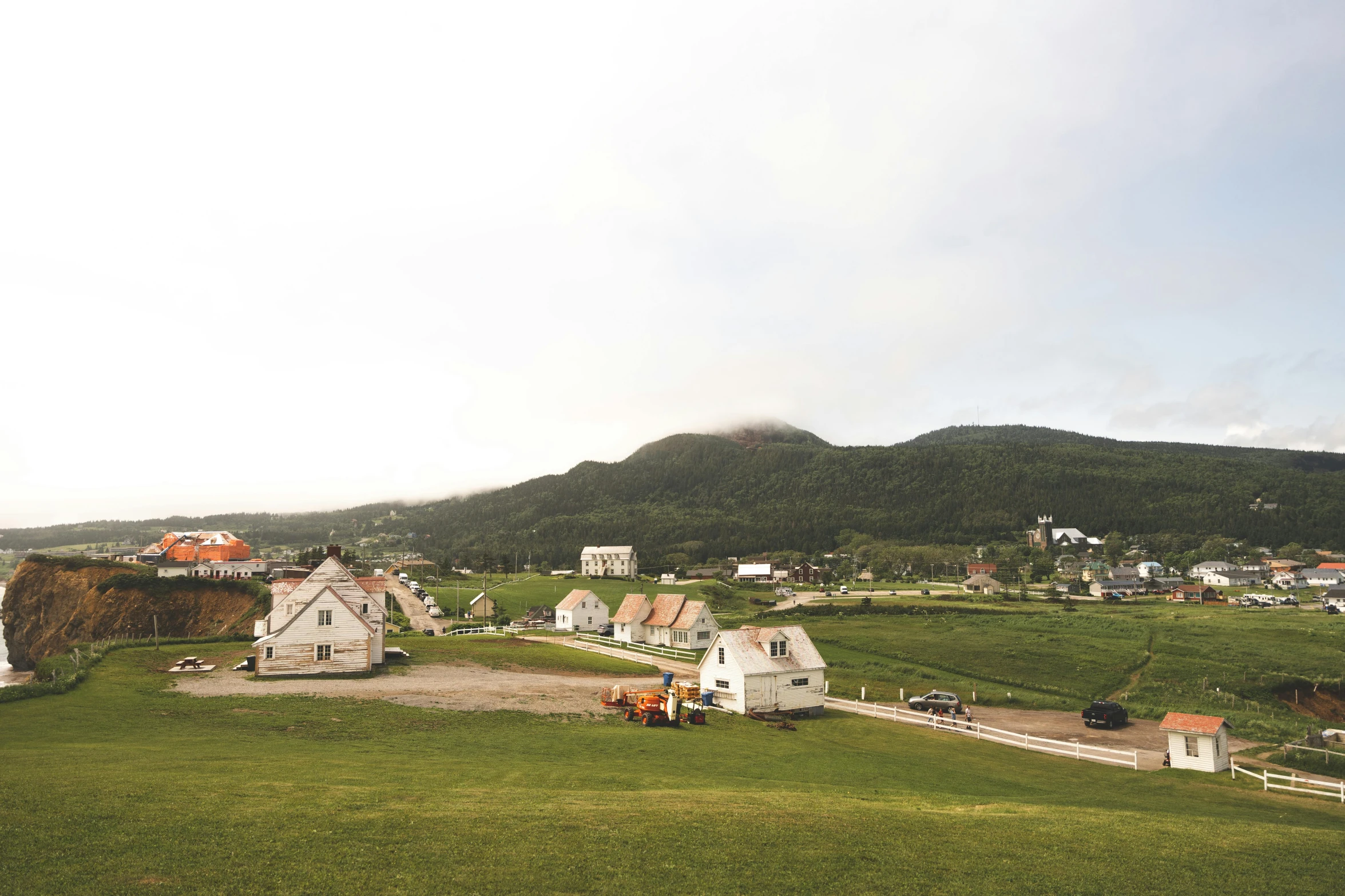 a big grassy hill with lots of buildings on it