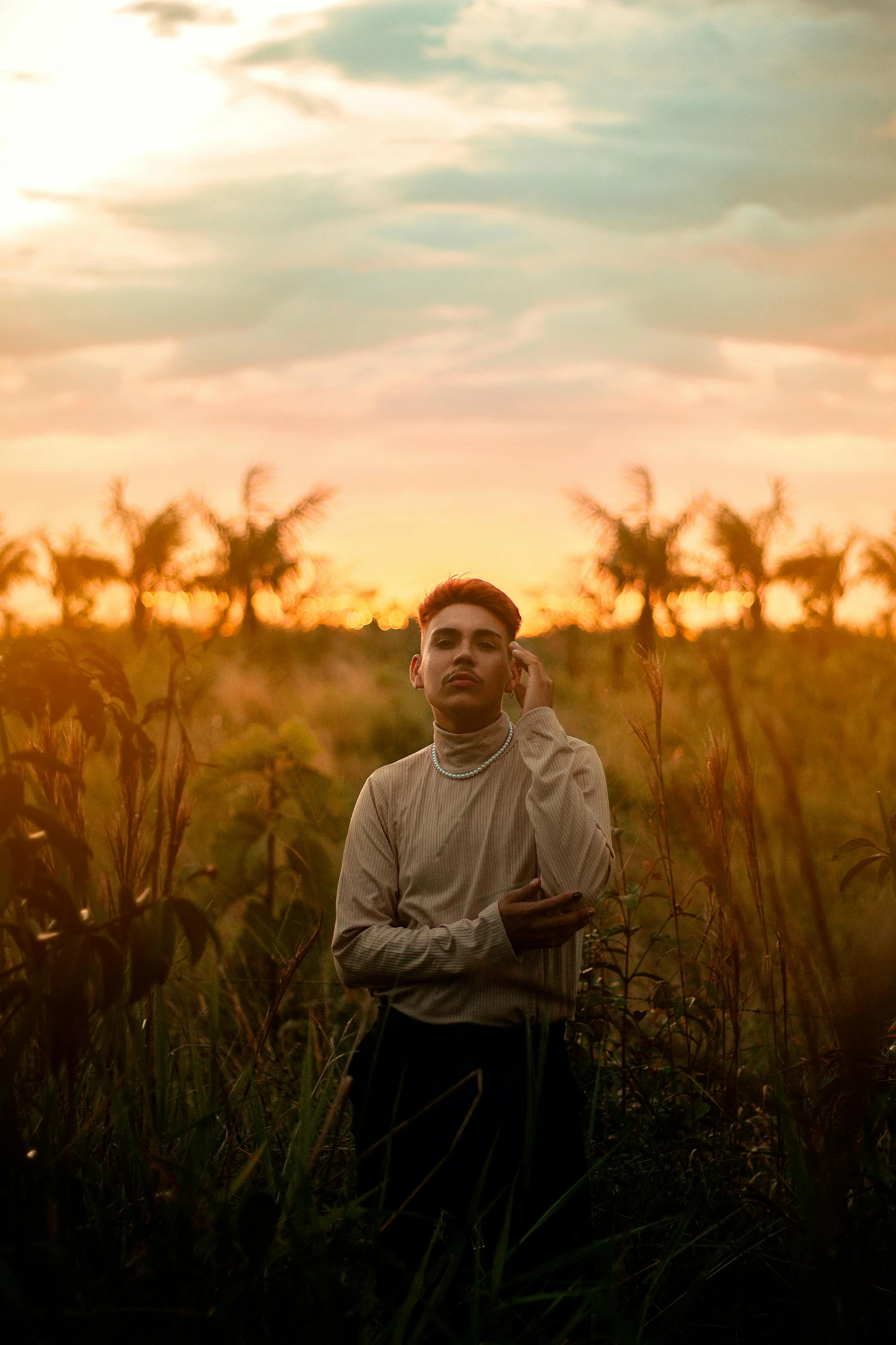 a man is standing in a field looking at the camera