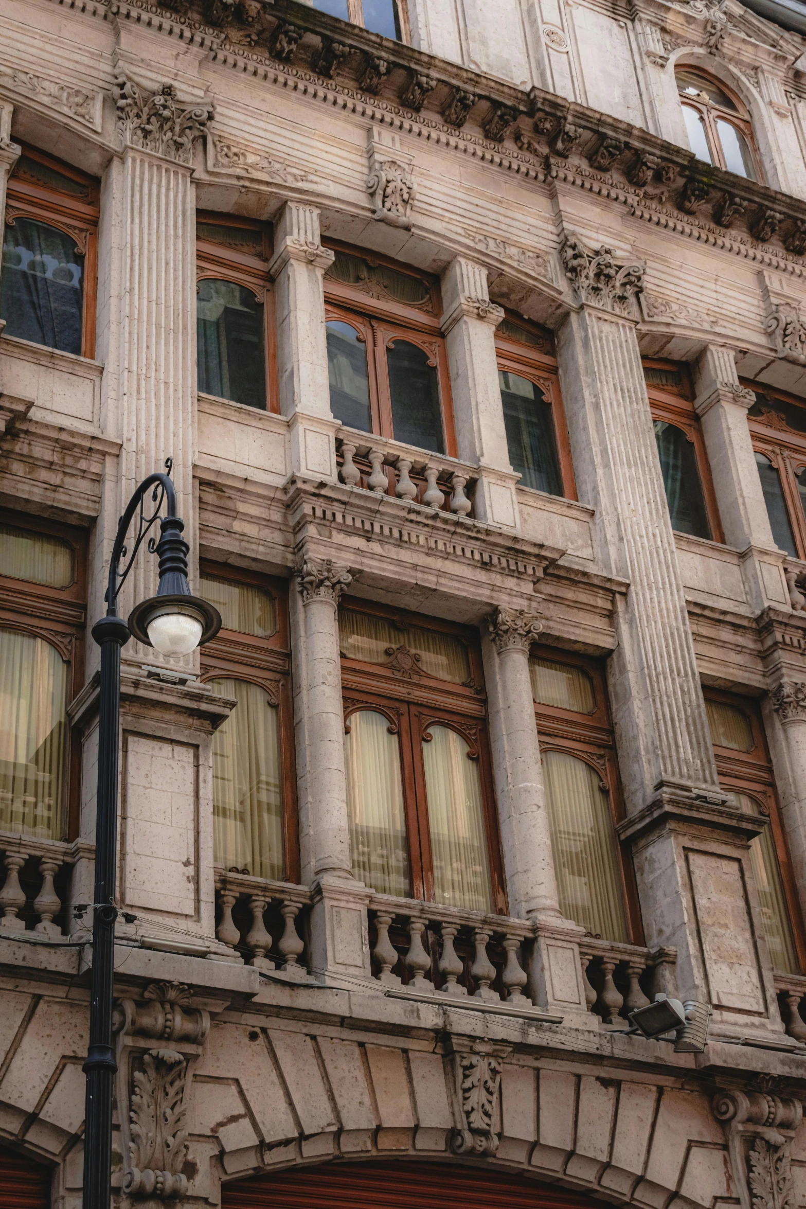 a light pole with two street lamps in front of a building