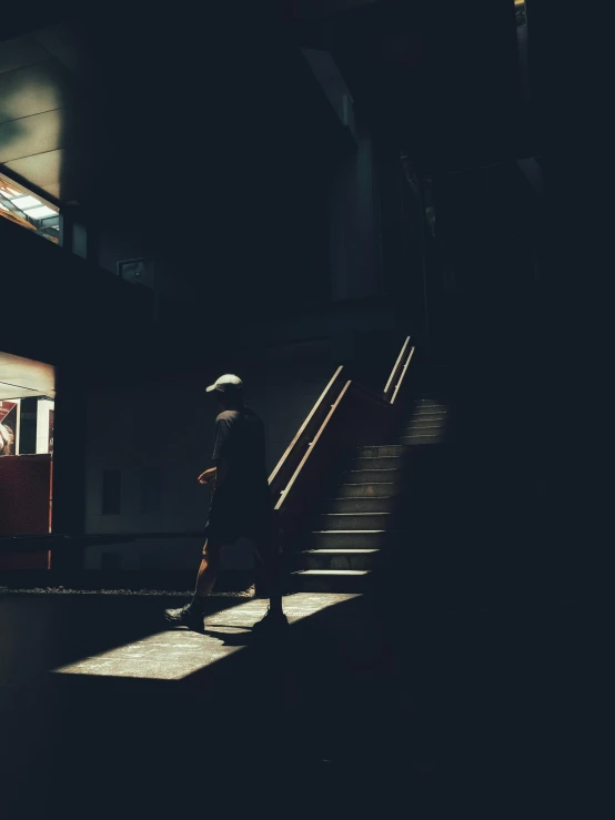 someone walking up some stairs with a lit staircase