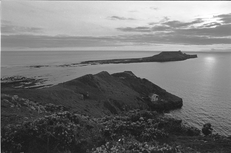 a small island that sits in the ocean on top of a hill