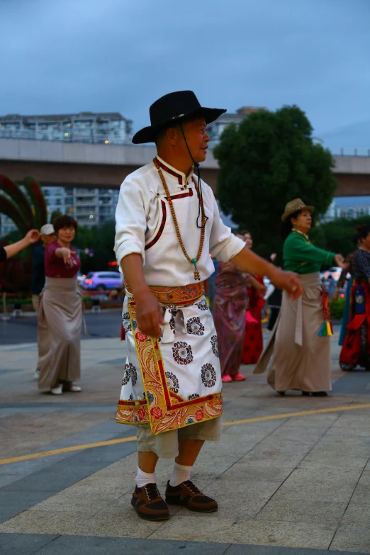 a man wearing a black hat stands with other people