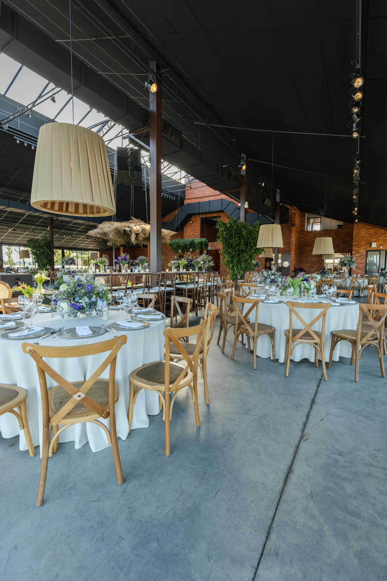 a group of wooden tables surrounded by chairs and a white table cloth