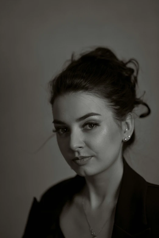 a black and white portrait of a woman with jewelry on