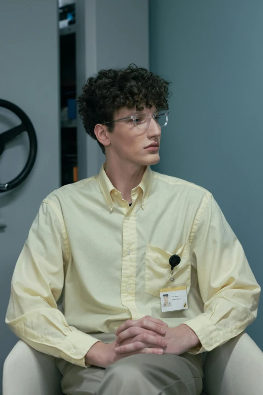 man in yellow shirt sitting in chair at the office