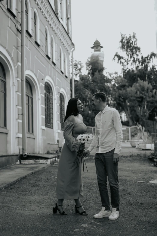 a man and woman are standing on the street next to the building