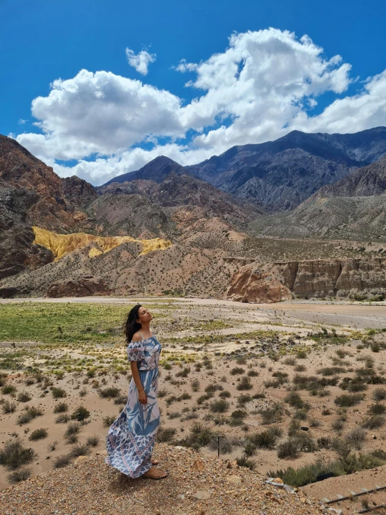 a woman standing on top of a dry grass covered field